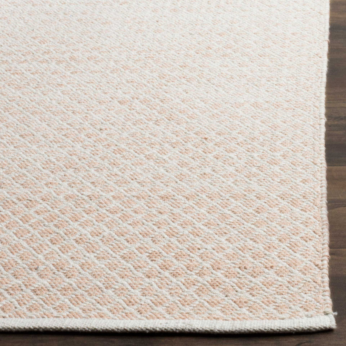 Tightly woven beige and ivory diamonds meet a neat bound edge for subtle texture underfoot.