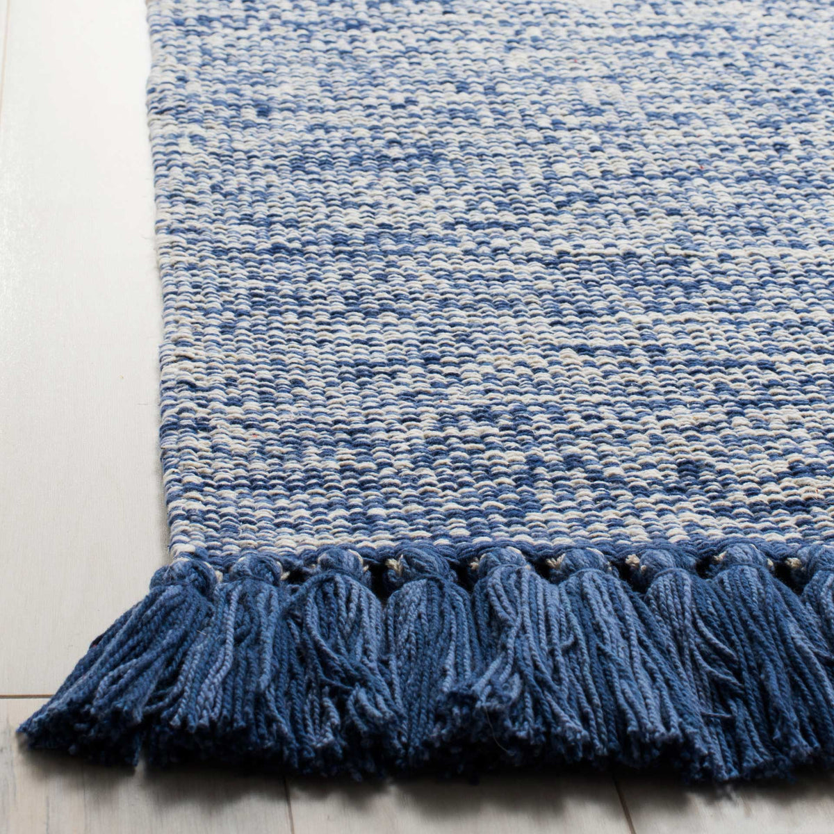 Thick blue tassels trim the edge of a softly heathered cotton weave.