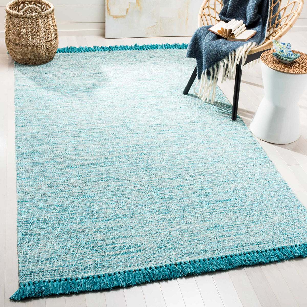A breezy turquoise rug brings fresh color to the floor, finished with rich teal fringe.