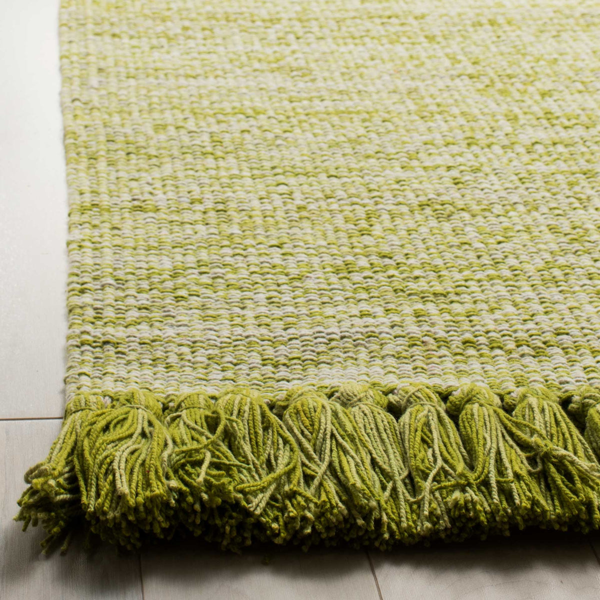 Chunky olive tassels and a textured two-tone weave bring earthy detail to the rug's edge.
