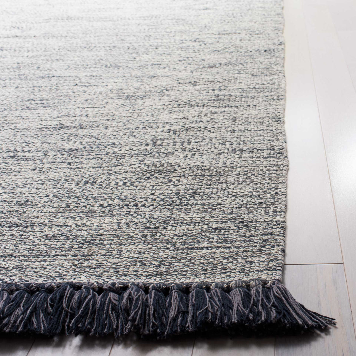 Charcoal fringe adds bold contrast to the rug's softly marled gray-and-ivory weave.