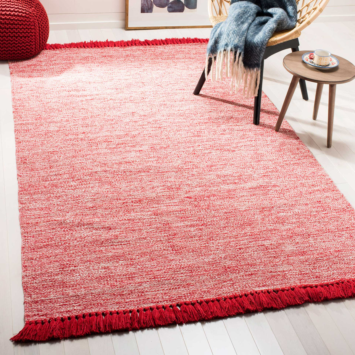A vibrant red rug anchors the floor with textured color and striking tassel fringe.