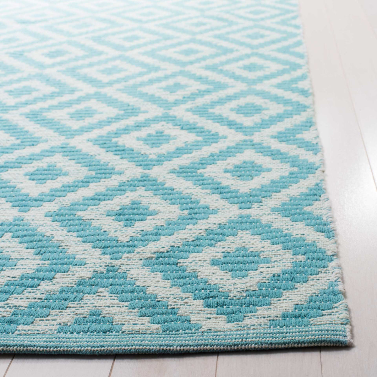 Woven blue diamonds and a tidy finished edge showcase the rug's textured cotton.