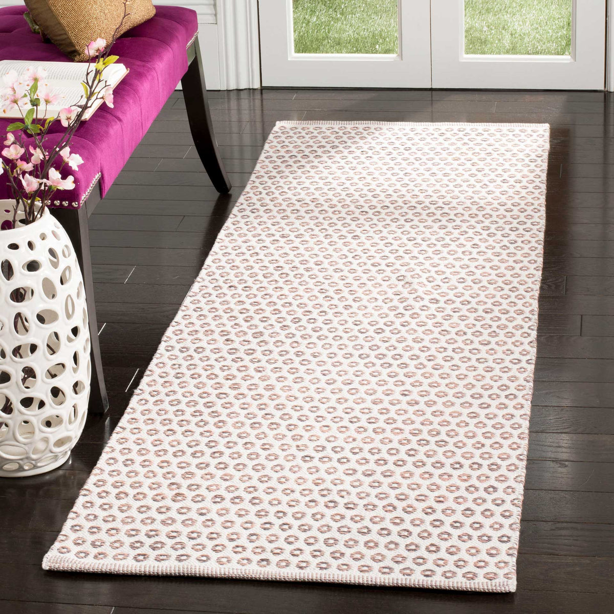 A low-profile cotton runner brings warm peach and charcoal pattern to an entryway.