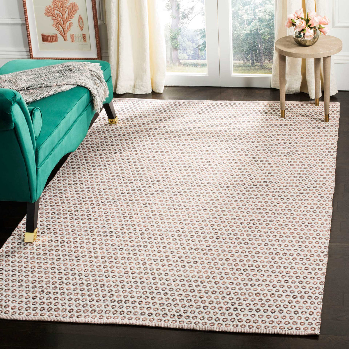 Ivory rug with peach and charcoal rings adds a soft geometric touch beside a teal sofa