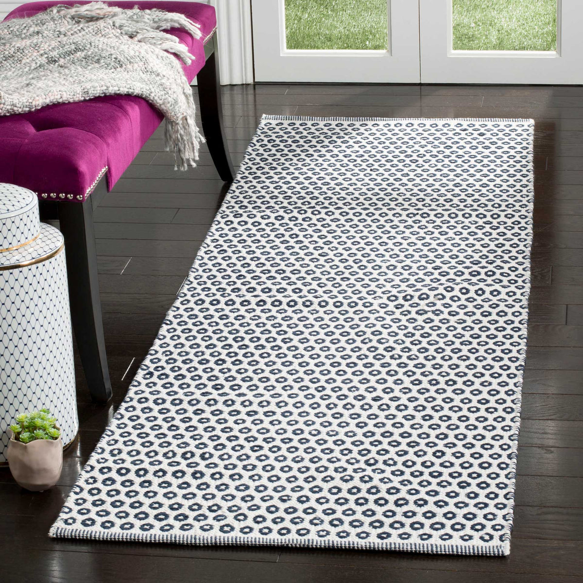 A navy and ivory cotton runner adds a bold, repeating pattern to an entryway.