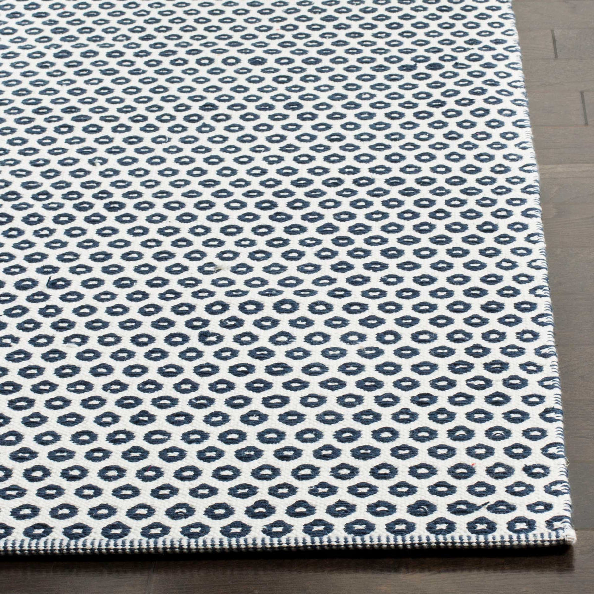 Deep navy ring motifs and a neatly finished edge stand out against the ivory cotton weave