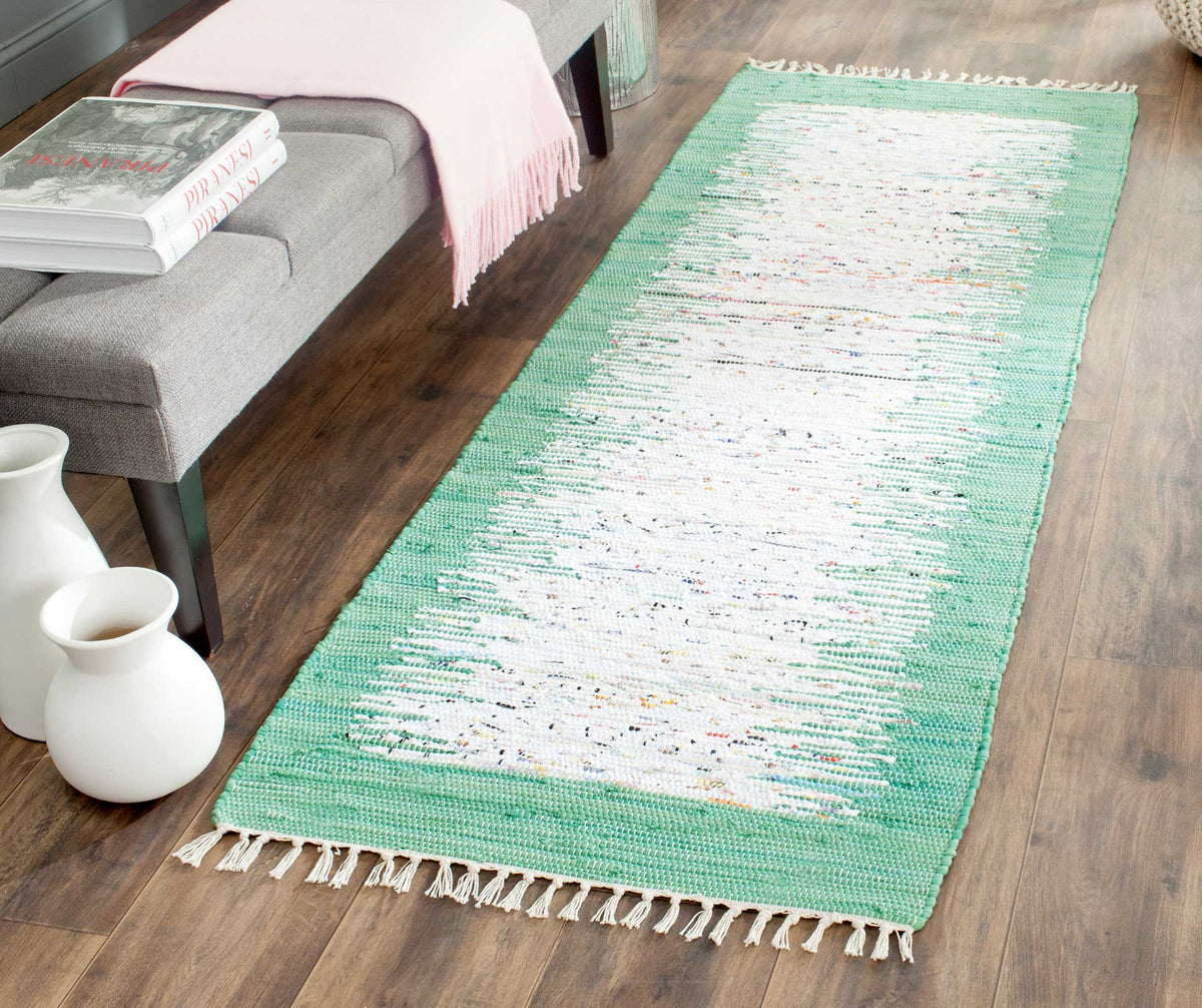 Sea green and ivory cotton bring refreshing color to wood floors beside a neutral bench.