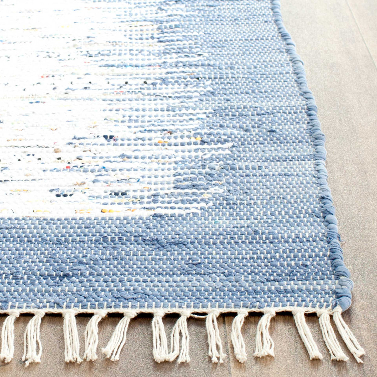Ivory fringe accents the blue woven edge and nubby cotton weave flecked with subtle colors.