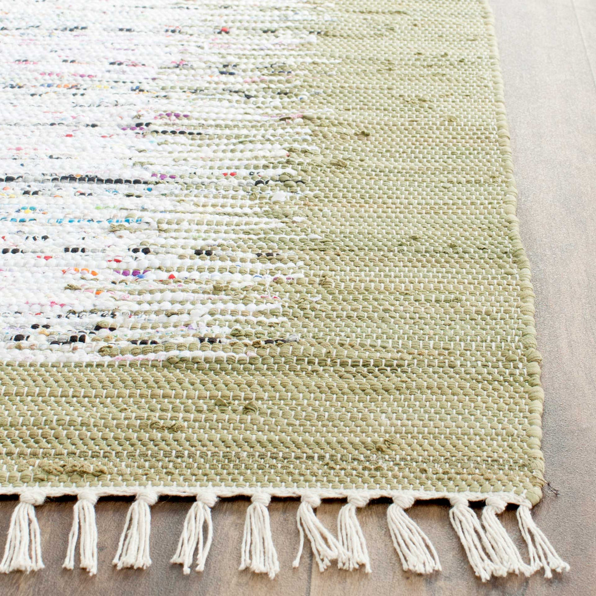 Olive and ivory cotton threads form a tactile, irregular weave with tasseled ivory fringe.