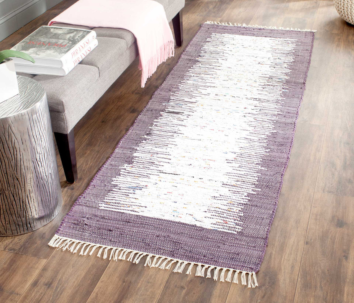 The ivory and purple runner lends a soft color accent to warm wood flooring and a gray bench.