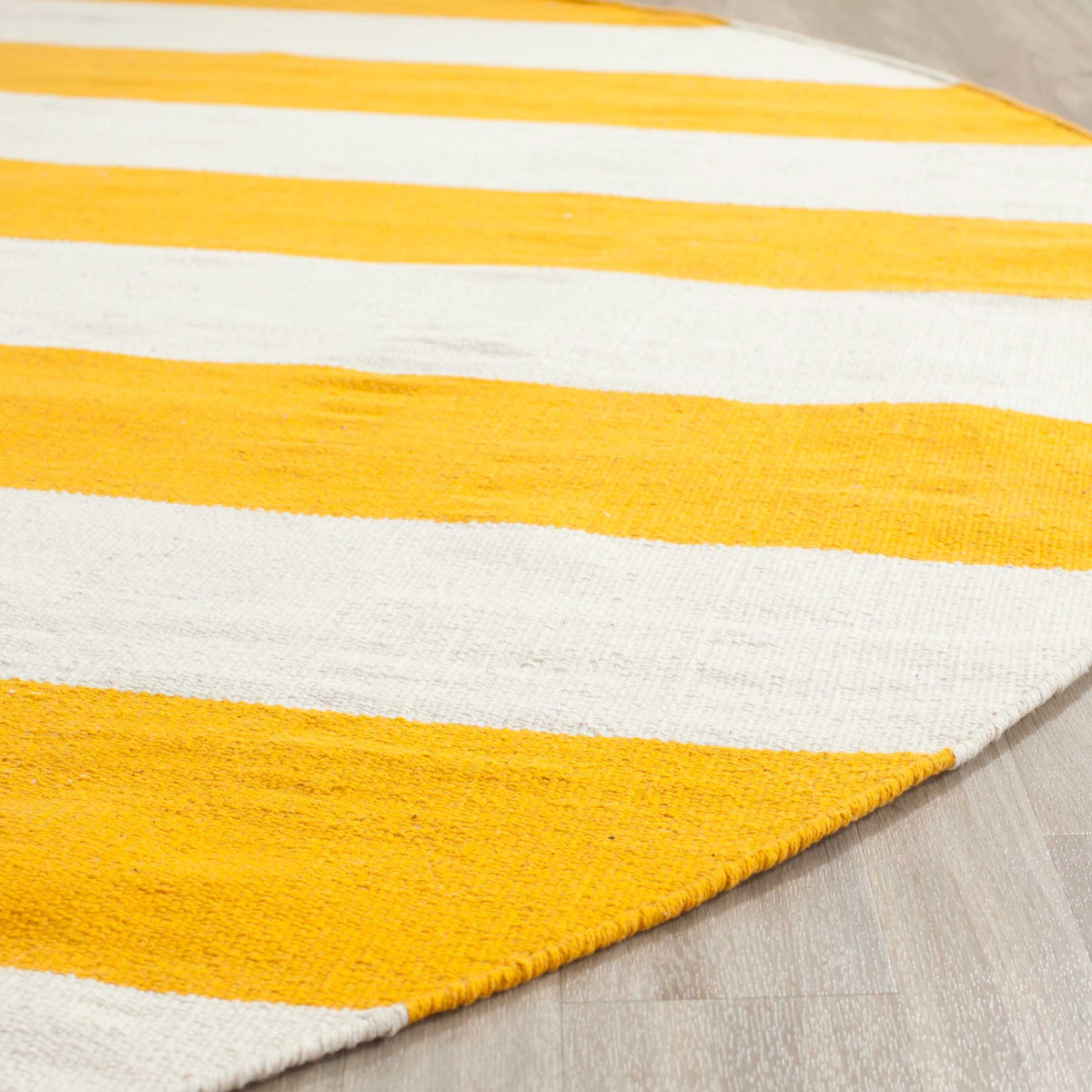 Yellow and ivory cotton bands reveal a textured weave and a cleanly finished curved edge.