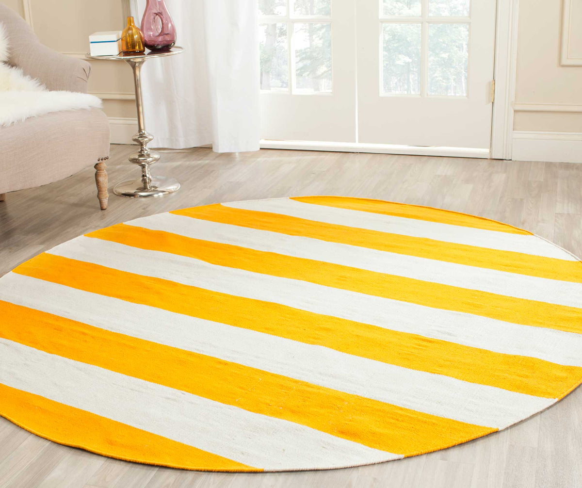 Bright yellow and ivory stripes bring a cheerful lift to this round rug on pale wood floors.
