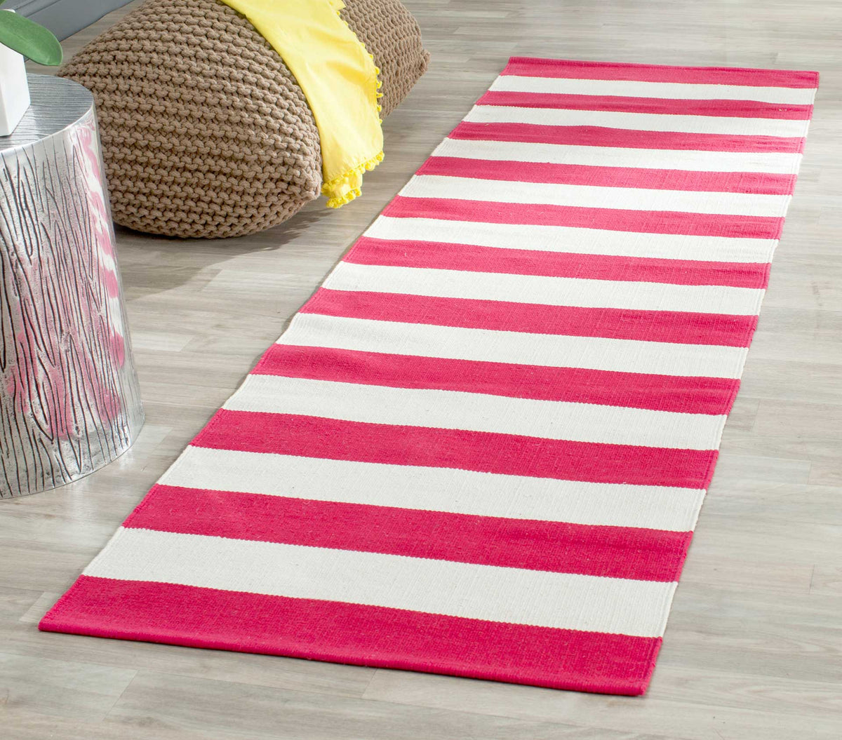 Bright red and ivory stripes enliven the floor beside a cozy knit pouf.