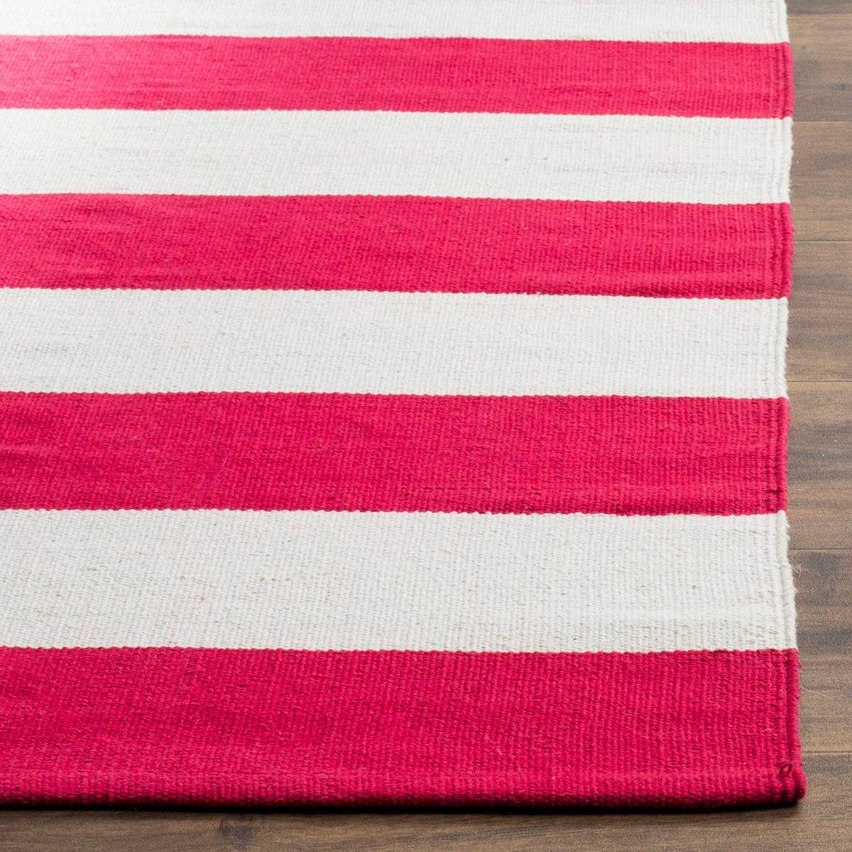 Finely woven red and ivory stripes meet a neatly finished rug edge.