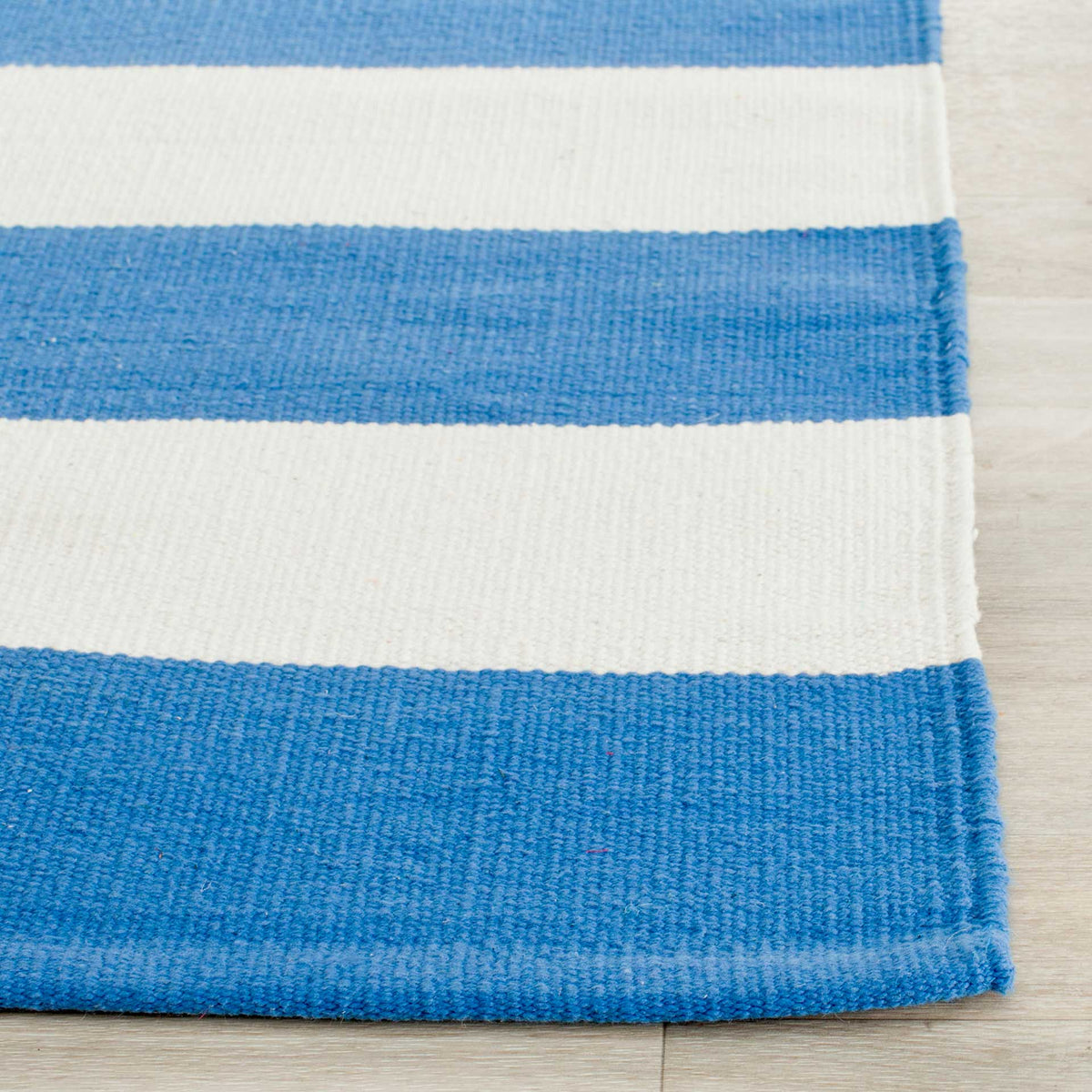 Textured cotton and neatly finished edges define the bright blue and ivory bands.