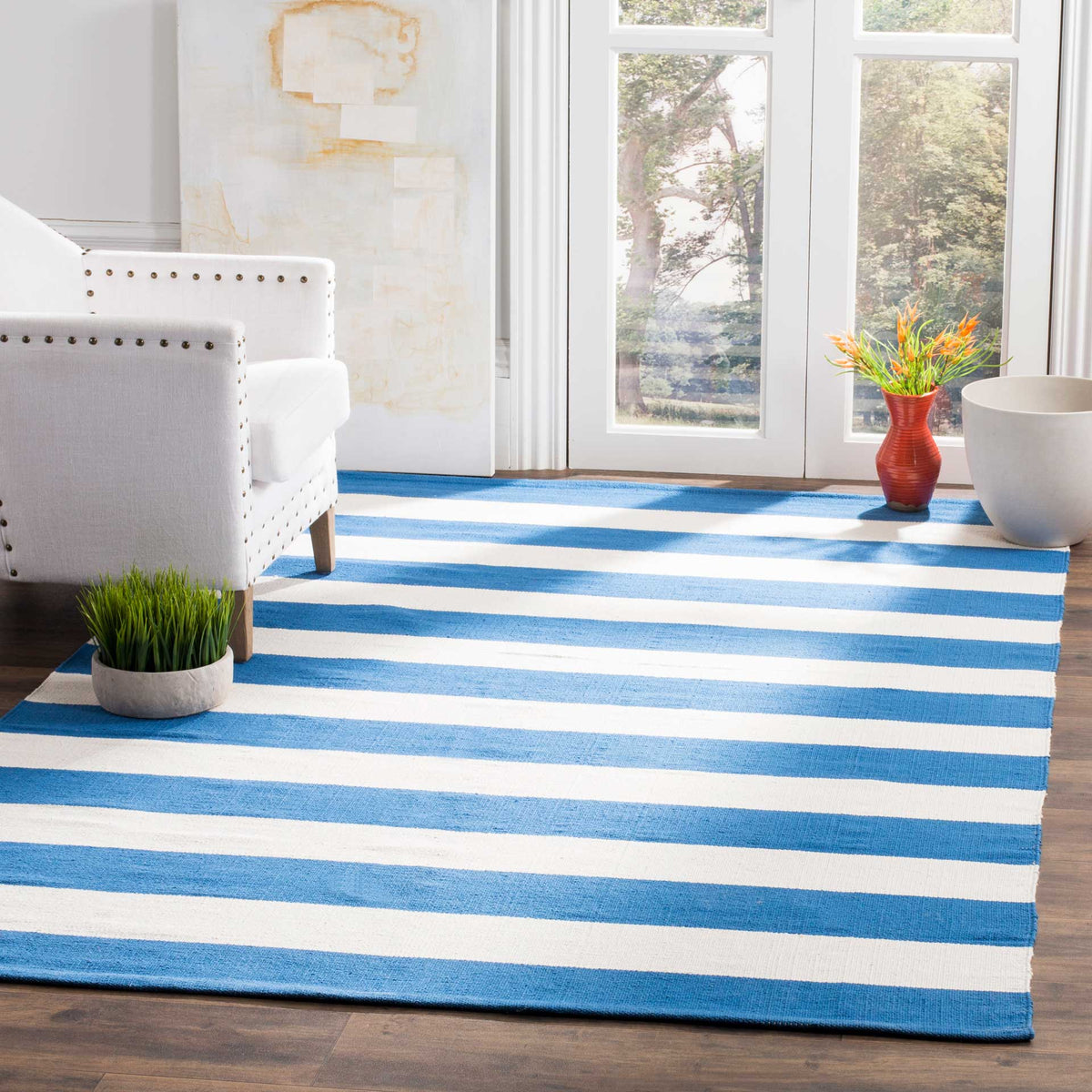 Vivid blue and ivory stripes ground a sunlit living space with coastal color.