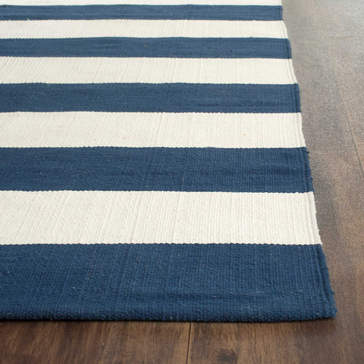 Alternating navy and ivory stripes reveal a textured weave and smooth finished edge.