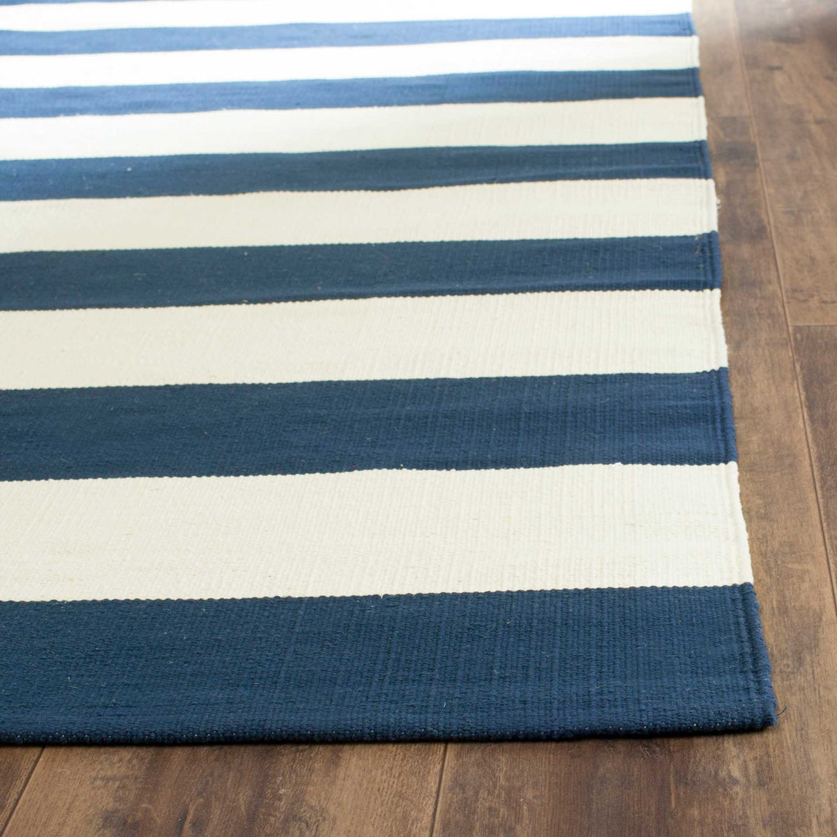 Woven navy and ivory stripes meet the neatly finished edge of this cotton rug.