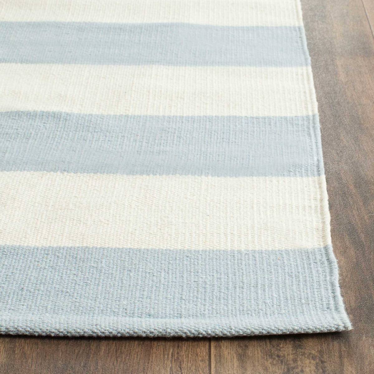 Fine sky blue and ivory cotton weaving meets a neatly finished, low-profile edge.