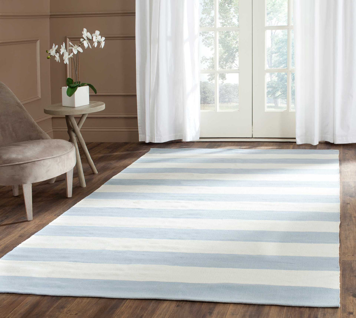 Soft sky blue and ivory stripes lighten a living space with understated coastal charm.