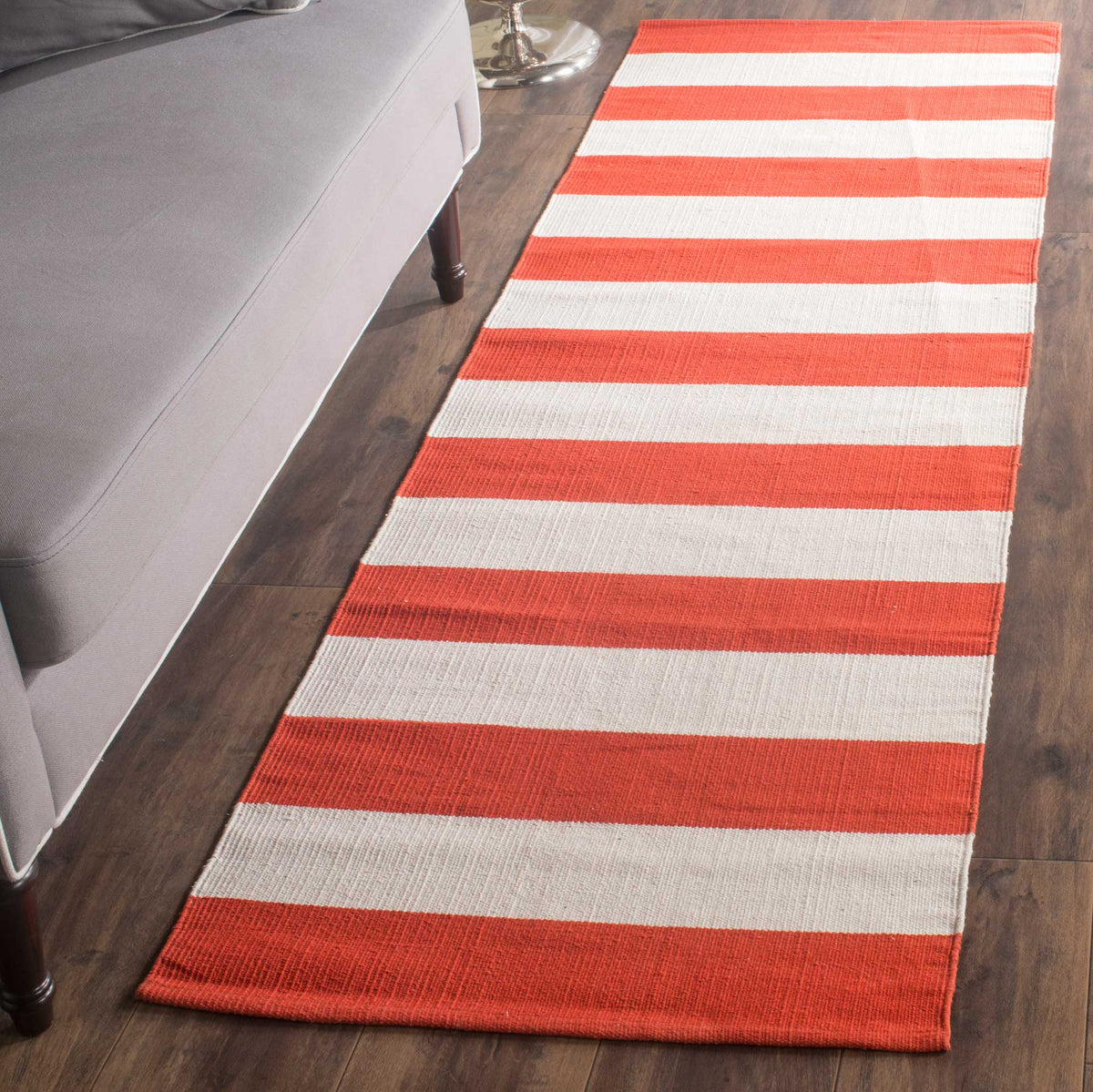 Warm rust and ivory stripes bring inviting color alongside a gray sofa.