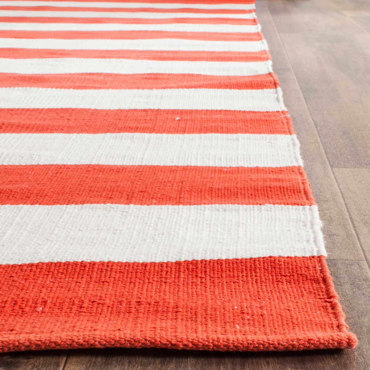 Textured rust-orange and ivory cotton bands meet a neatly finished corner.