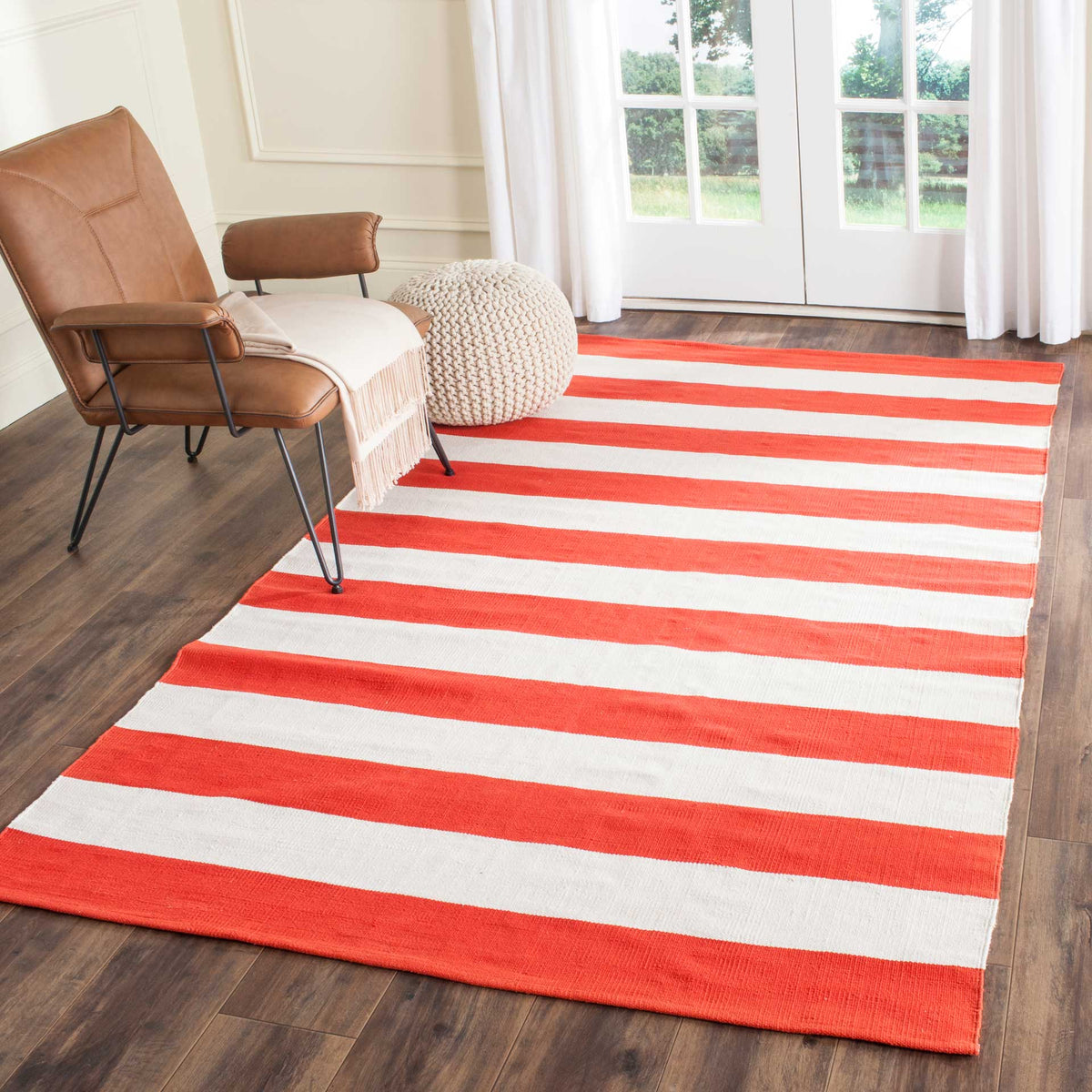 Warm orange-red and ivory stripes add cozy color beside a casual lounge chair.