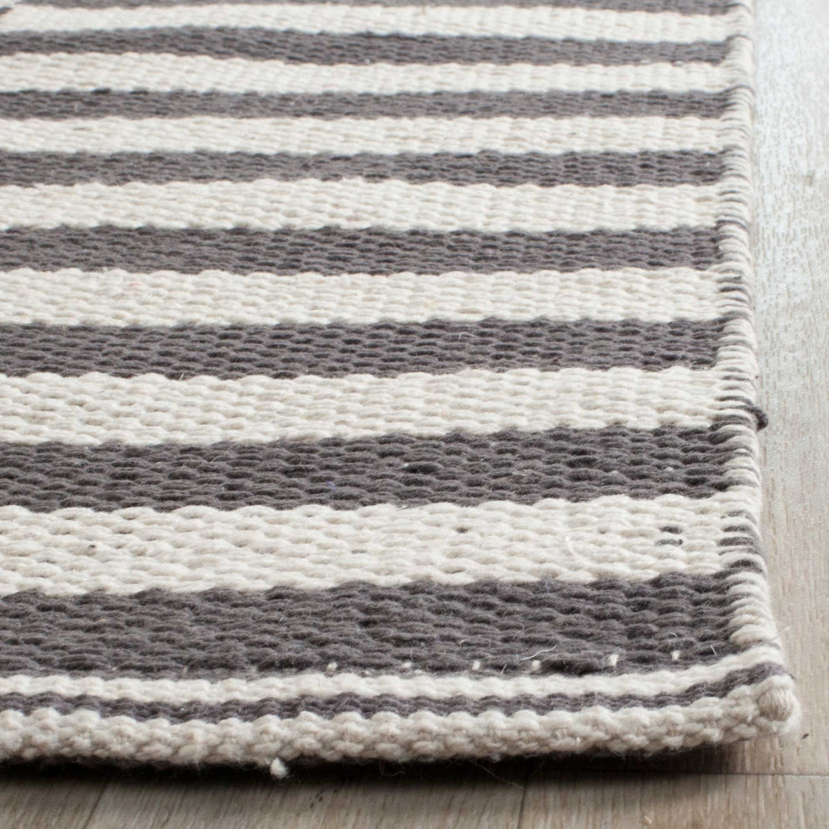 Woven gray and ivory stripes end in a rounded, neatly bound corner