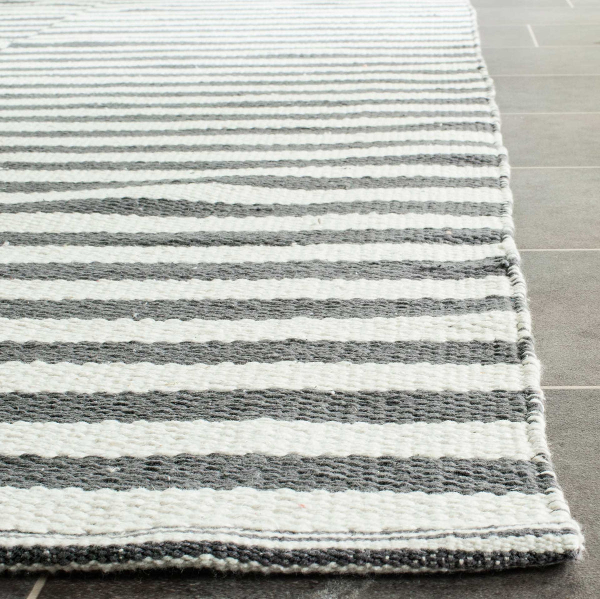 Gray and ivory cotton stripes meet at a softly textured, neatly bound corner.