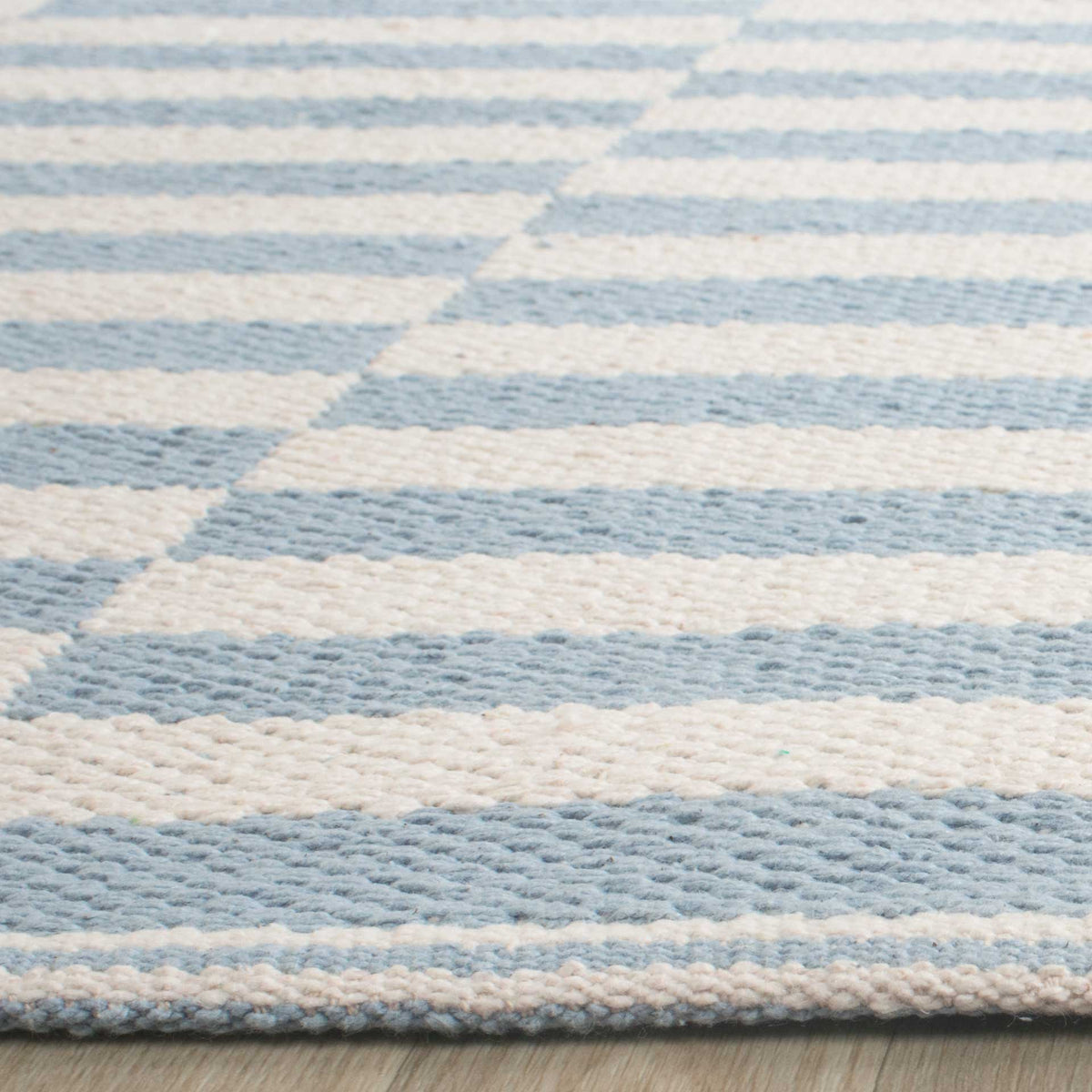 Pale blue and ivory bands reveal a textured weave and low-profile bound edge