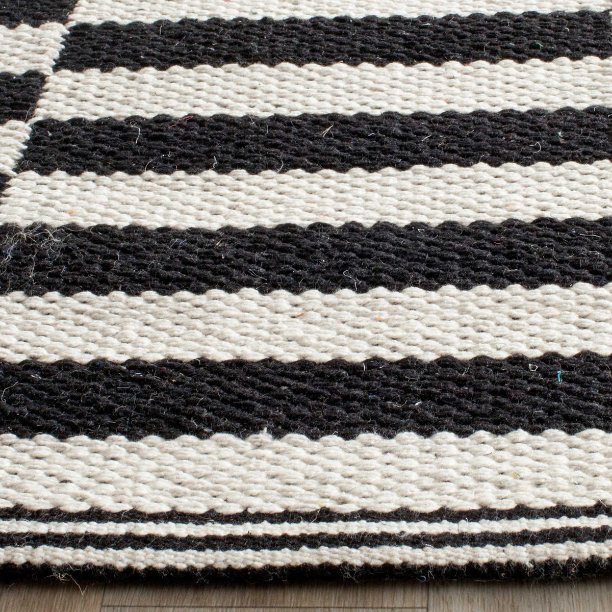 Textured cotton yarns and a bound edge accent the bold black-and-ivory stripes