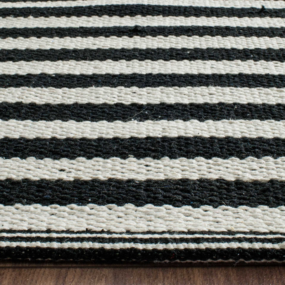 Tightly woven black and ivory stripes meet a neatly finished cotton edge.