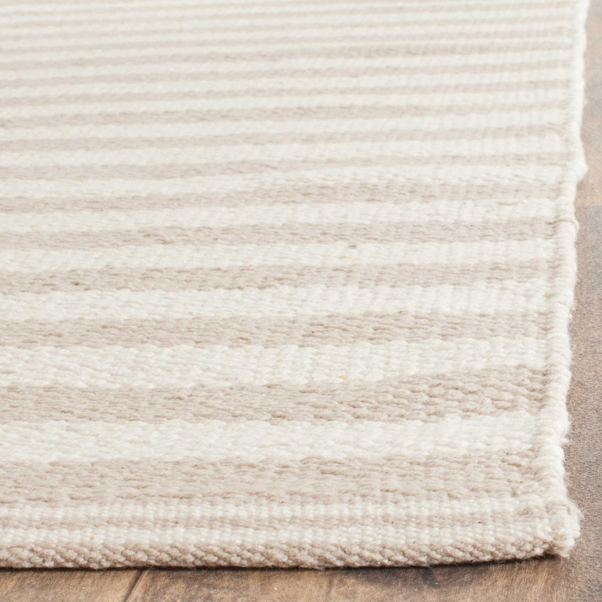 Fine ivory and warm gray stripes meet at a softly bound cotton corner.