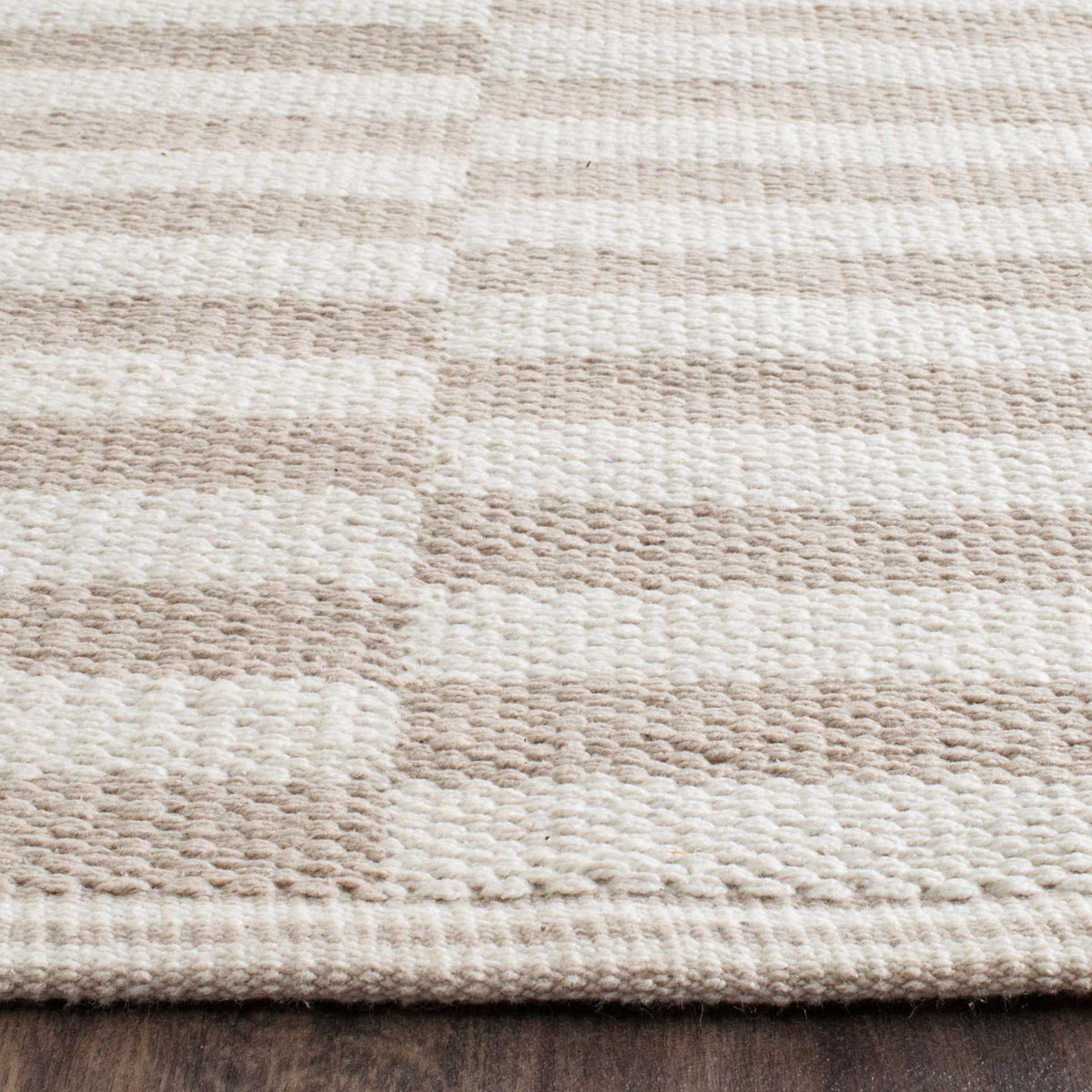 Warm light gray and ivory cotton yarns create understated stripes and a finished edge.