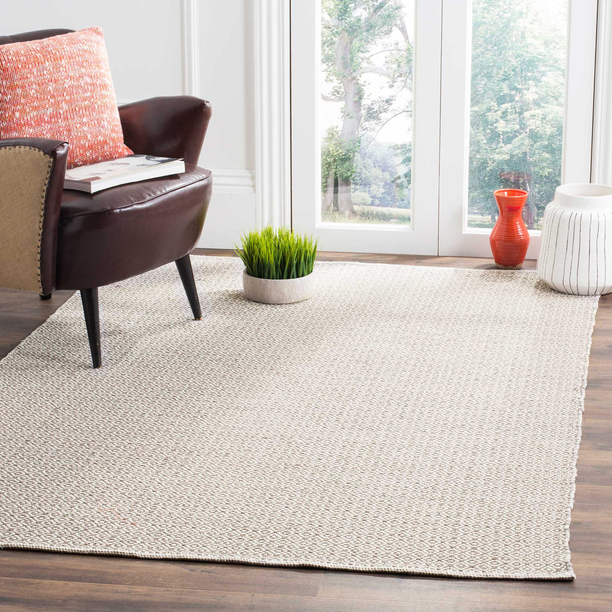 An ivory and gray geometric rug brings quiet texture and natural cotton warmth to the floor.