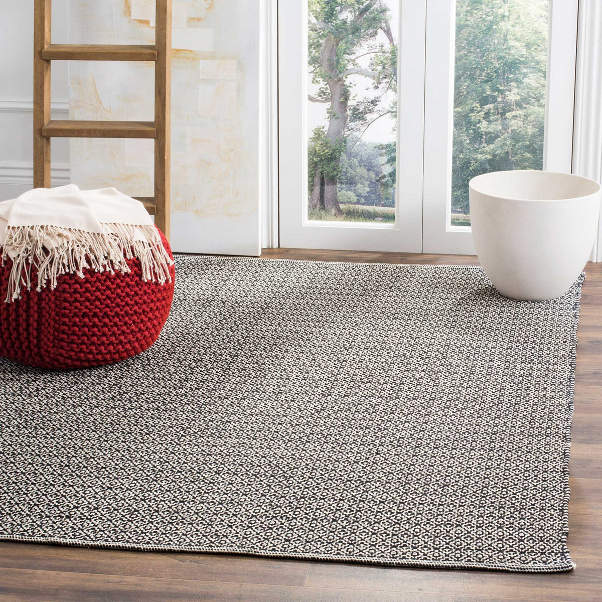 An ivory and black patterned rug brings graphic contrast and woven texture to the floor.