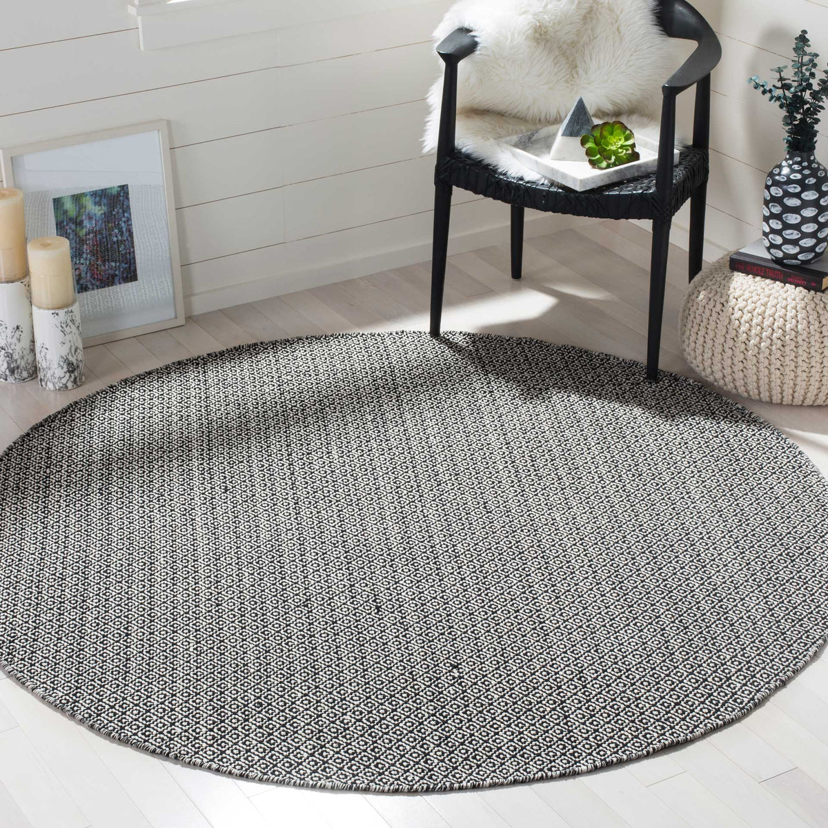 Round ivory and black rug brings bold geometric pattern to a bright seating area