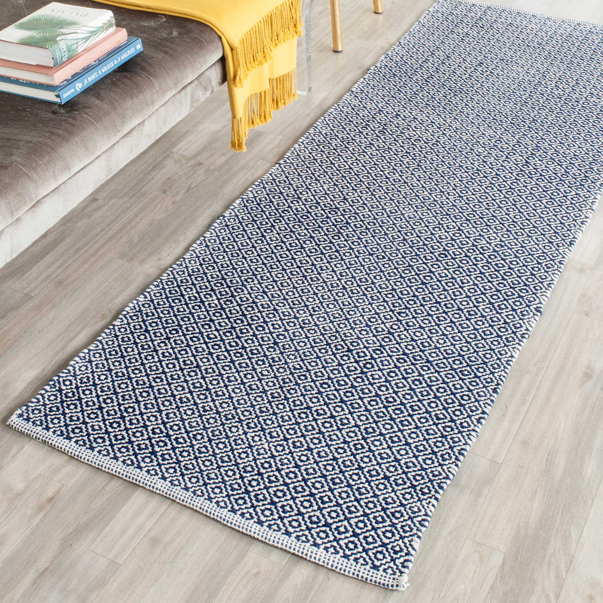 Navy and ivory geometric motifs add crisp contrast to a handwoven runner beside a sofa.