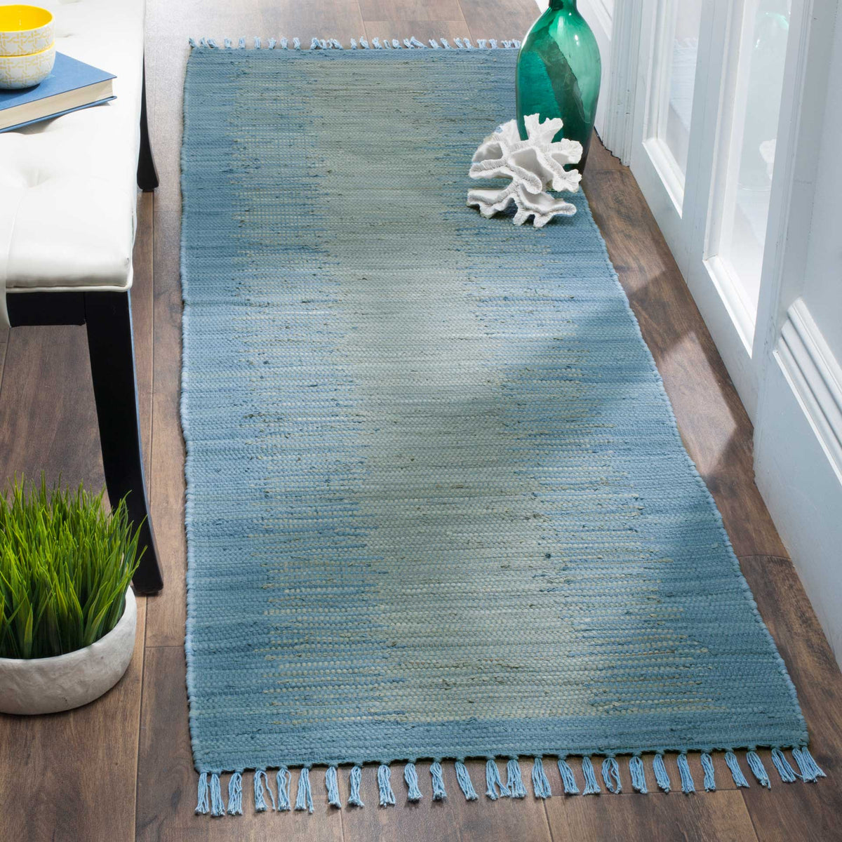 Woven light blue cotton and playful end fringe lend relaxed charm to this slim runner.