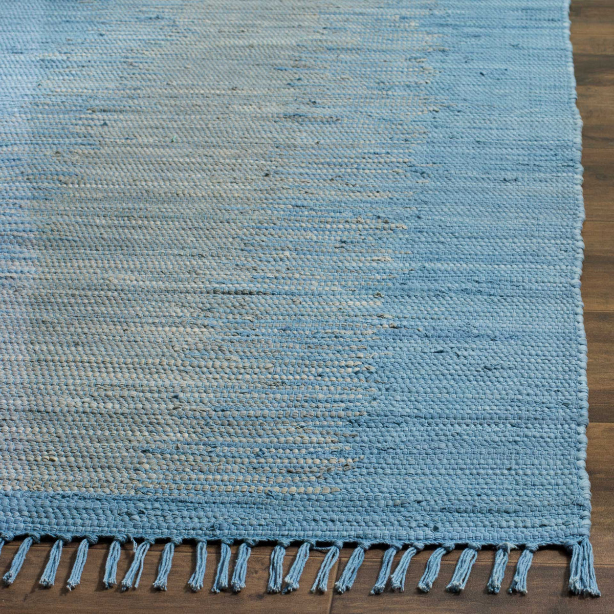 Blue and gray cotton yarns form a chunky textured weave and tasseled edge