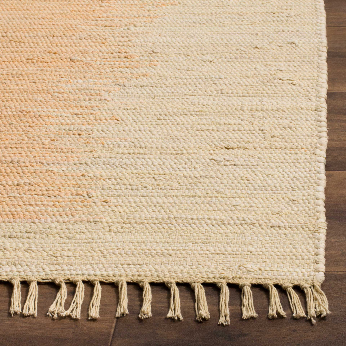 Interwoven ivory and beige cotton yarns reveal a tactile surface and loose fringe