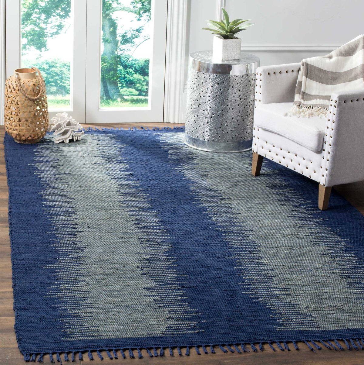 Deep navy woven rug adds contrast with smoky blue-gray bands and tasseled ends