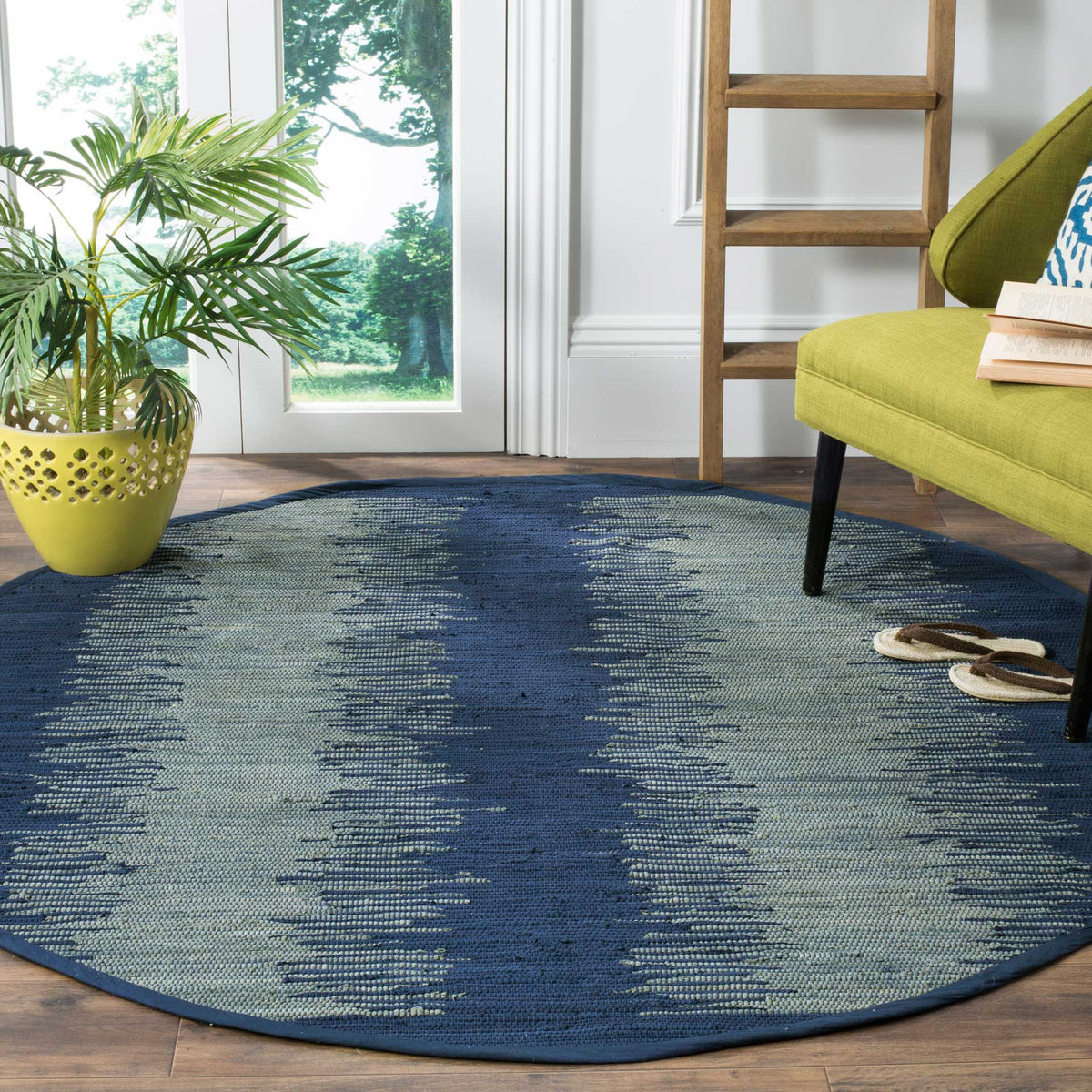Bold navy and muted gray markings anchor this round, low-profile cotton rug