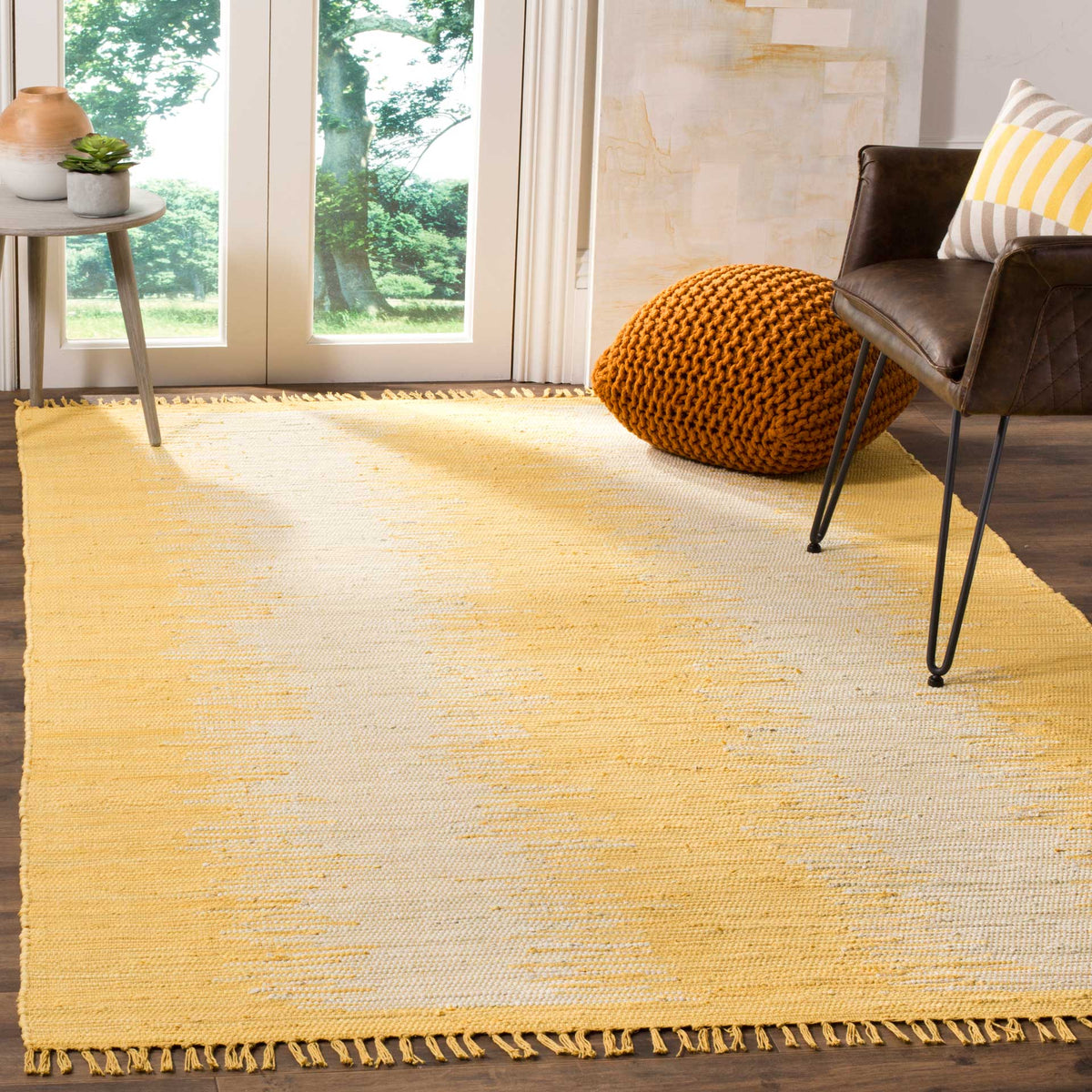 Golden woven bands and ivory streaks lend warmth to a fringed cotton rug