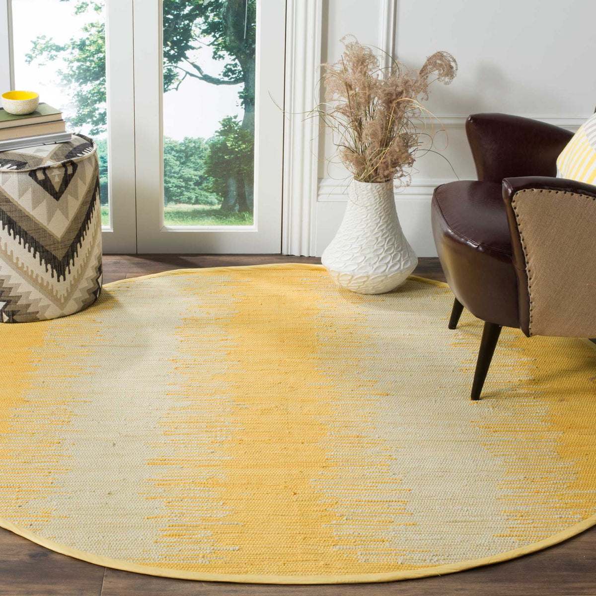 Warm golden tones brighten a low-profile round rug with softly broken pale stripes