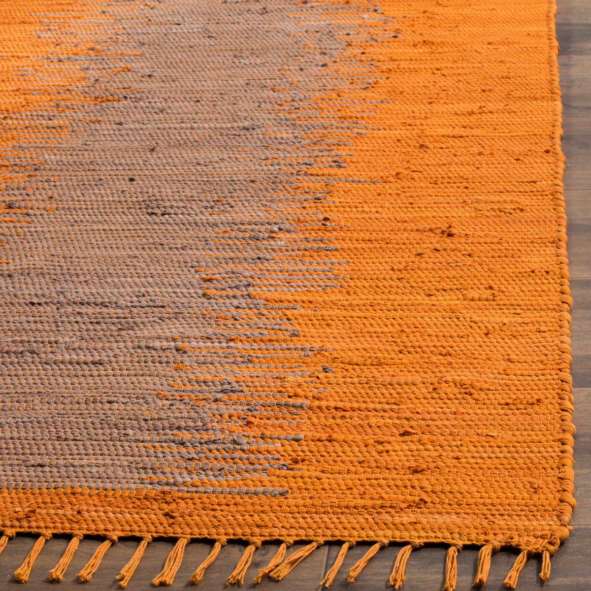 Orange and gray cotton fibers reveal a textured weave with loose fringe along the edge