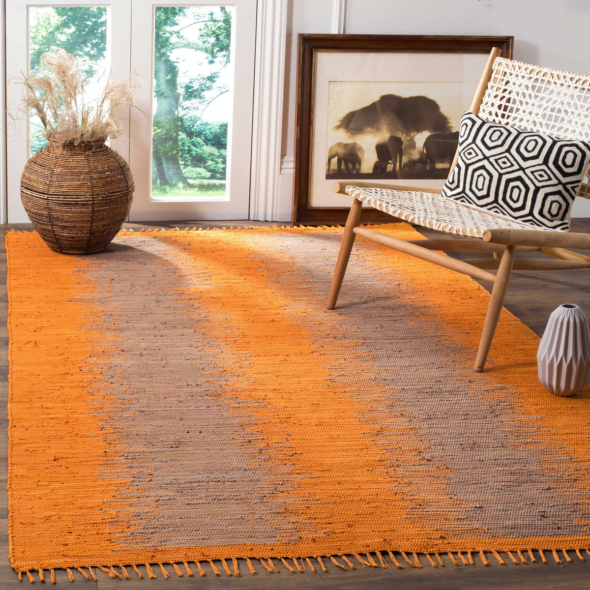 Warm orange and gray abstract bands give a fringed cotton rug vibrant character
