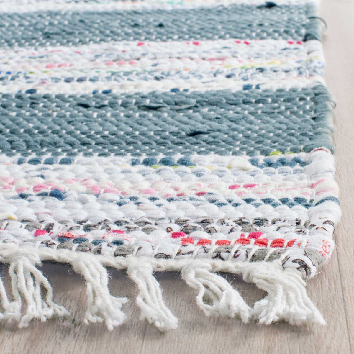 Colorful flecks and chunky woven texture finish in soft ivory fringe.