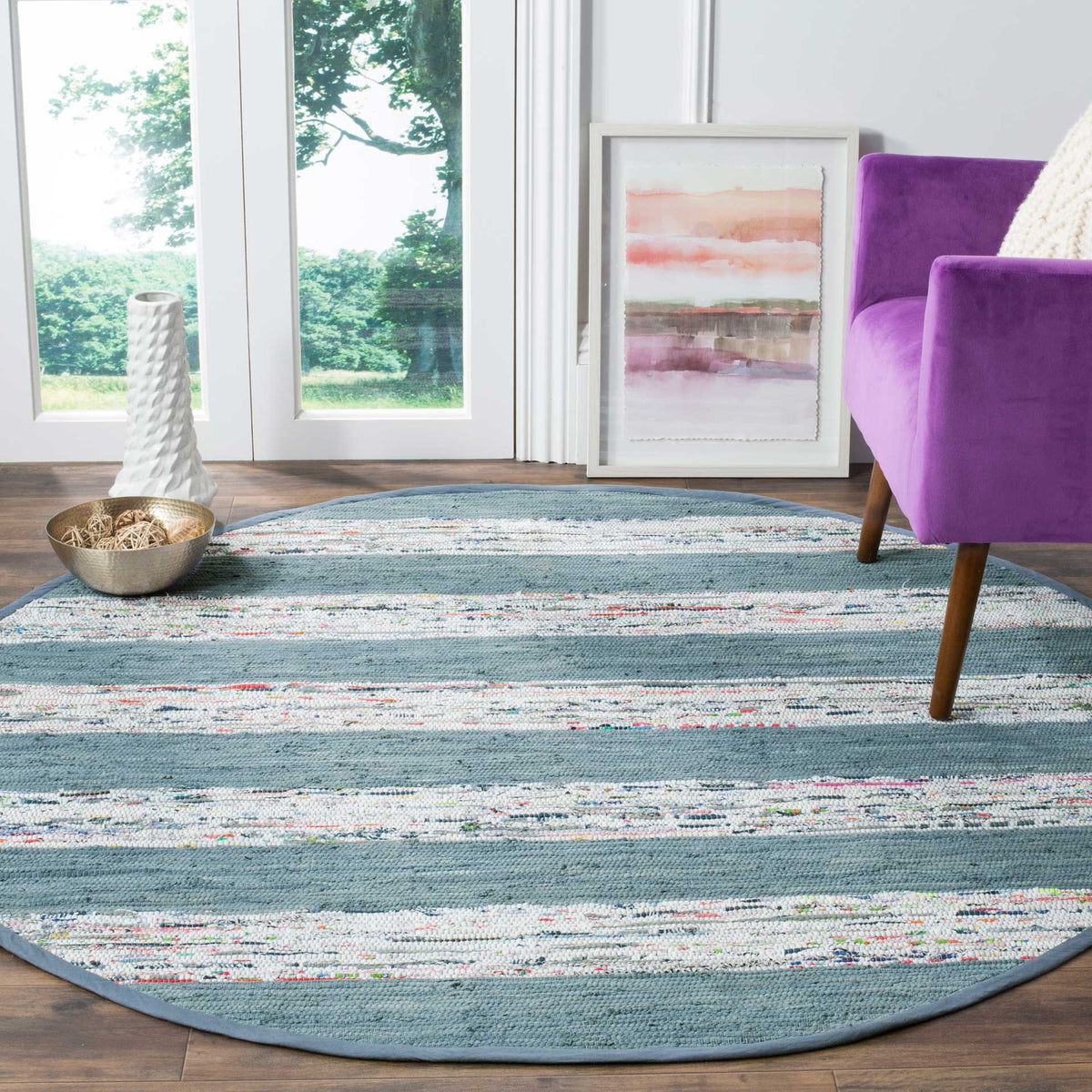 Round cotton rug adds cool blue-gray and ivory stripes to a bright living space.